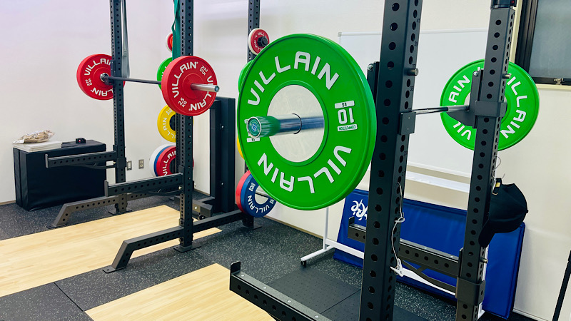 パワーラックとスクワットラックにそれぞれプレートが装着されたバーベルが設置されている