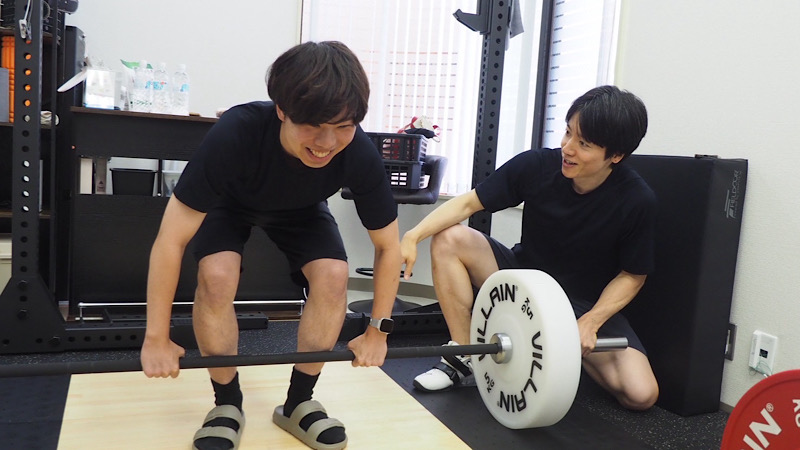マンツーマン指導のもと、トレーナーに見守られながら笑顔でトレーニングに励むお客様の様子。