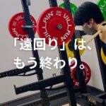 パーソナルトレーナーからバーベルスクワットの指導を受ける女性