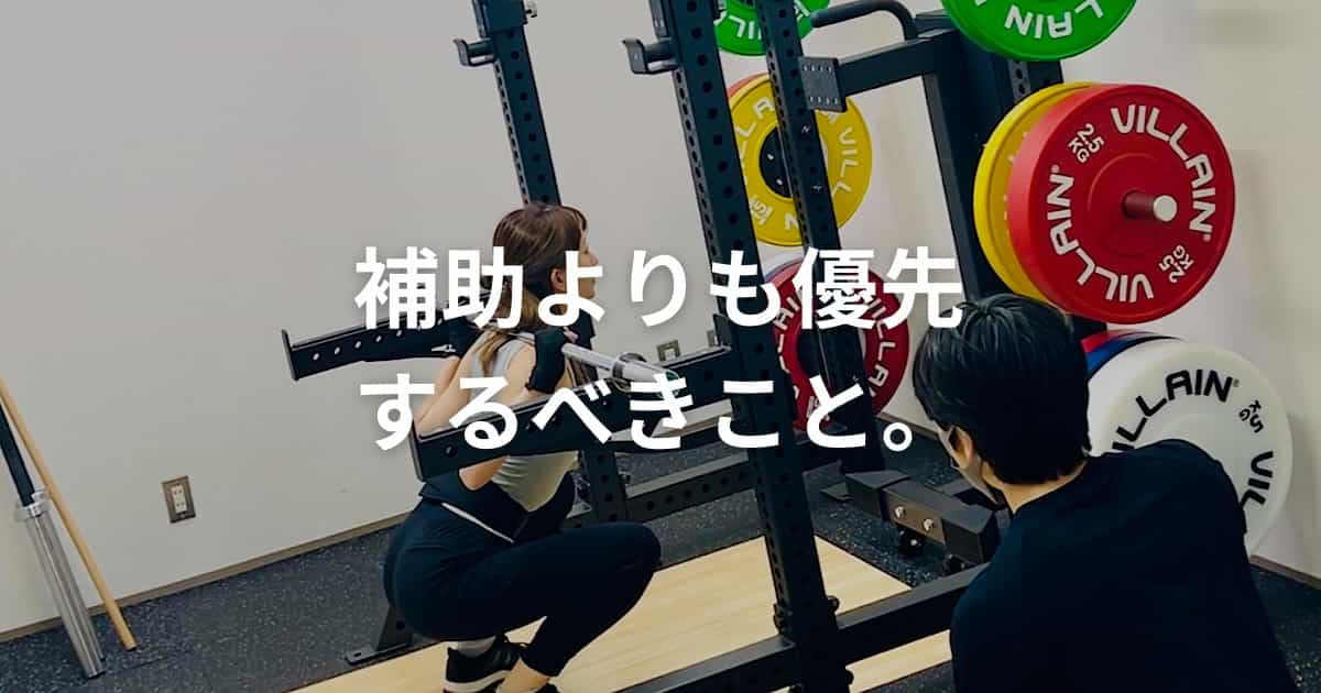 補助よりも優先すべきことという文字が表示されたスクワット指導の様子