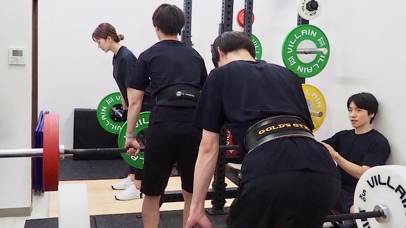 3人グループのお客様に、セミパーソナルトレーニングでデッドリフトを指導している様子。