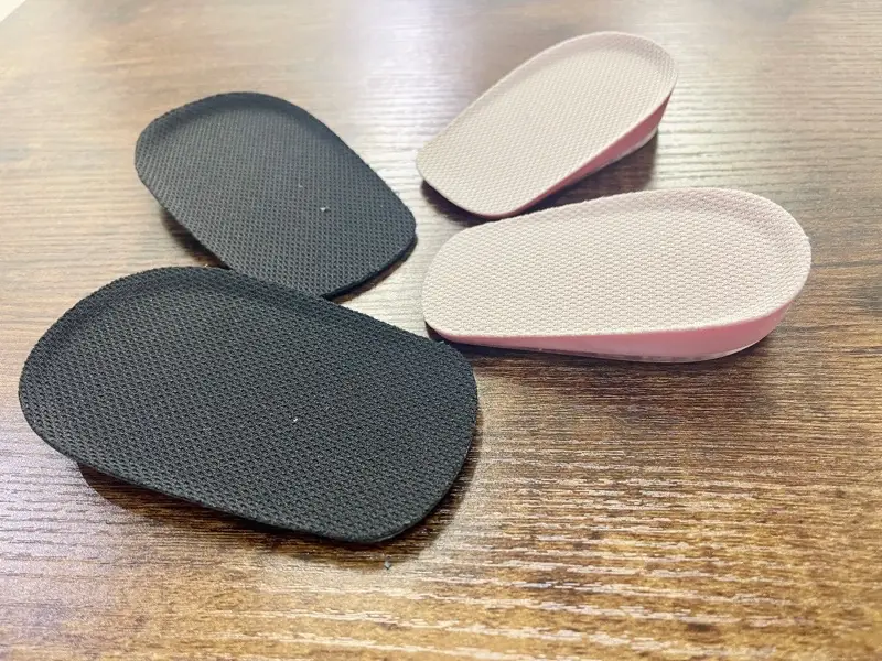 左側に黒い大サイズ、右側に白い小サイズのインソールが並べられている様子。