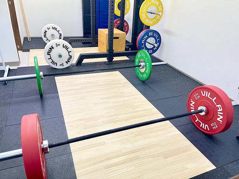 重量をドロップできる衝撃吸収プラットフォーム。デッドリフト用にセッティングされた3組のバーベル。