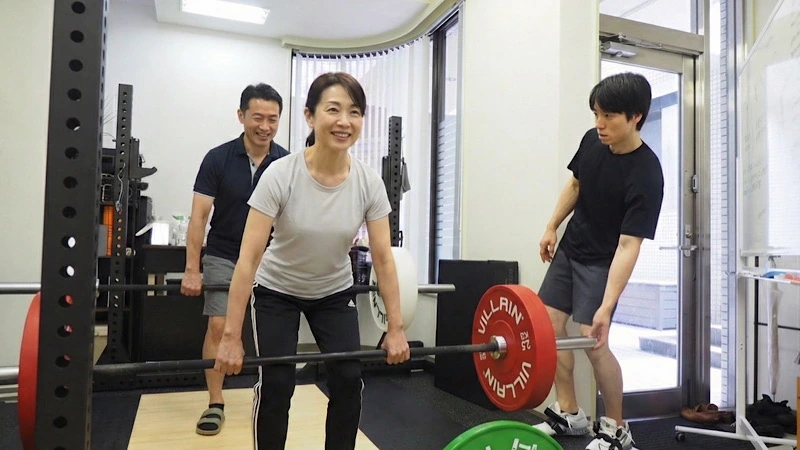 40代のご夫婦のお客様に、セミパーソナルトレーニングでデッドリフトを指導している様子。