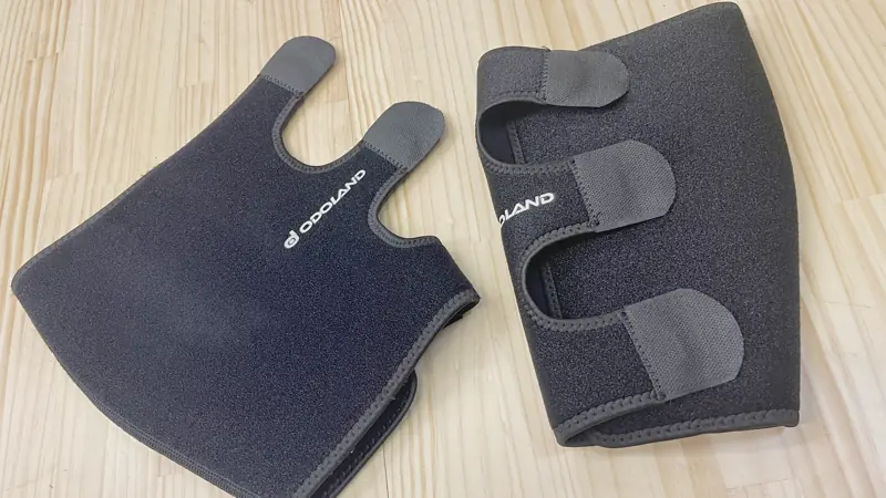 台に置かれた黒いスネ用サポーター。スネに巻き付けて三点のマジックテープで固定できる仕様になっている