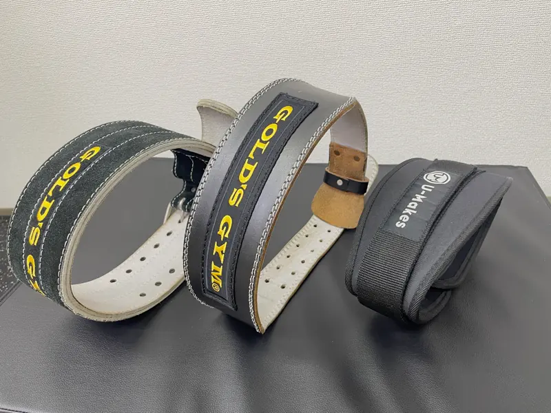台の上に並べられた3つのトレーニングベルト。左の２つが革製で右のひとつがナイロンタイプ。