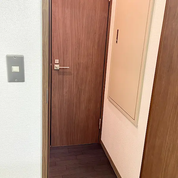 更衣室入り口。プライバシーに配慮した落ち着いた木目調のドアと清潔感のある空間。