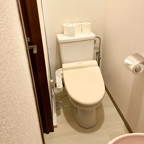 清潔感のある温水洗浄便座付きのトイレ。白を基調とした、手入れの行き届いたクリーンな空間。